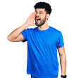 © Krakenimages.com - Young arab man with beard wearing casual blue t shirt shouting and screaming loud to side with hand on mouth. communication concept.
