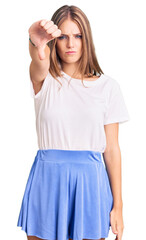 Wall Mural - Young beautiful blonde woman wearing summer style looking unhappy and angry showing rejection and negative with thumbs down gesture. bad expression.