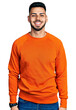 © Krakenimages.com - Young hispanic man with beard wearing casual orange sweater with a happy and cool smile on face. lucky person.