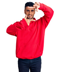 Canvas Print - Young hispanic man wearing casual clothes smiling making frame with hands and fingers with happy face. creativity and photography concept.