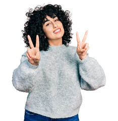 Poster - Young middle east girl wearing casual clothes smiling looking to the camera showing fingers doing victory sign. number two.