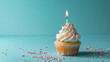 Birthday cupcake with candle on light blue table against blurred blue background. Party banner with copy space for festive celebrations and happy occasions.