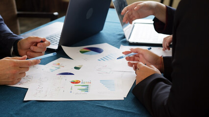 Close-up of business people working, busy with customer service team work, control pad and online sales, profit statistics, paper on table in staffing idea in work coworking space.