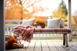 plaid blankets on porch bench with autumn farmhouse backdrop