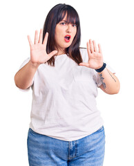 Sticker - Young plus size woman wearing casual clothes doing stop gesture with hands palms, angry and frustration expression