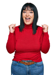 Poster - Young hispanic woman wearing casual clothes celebrating surprised and amazed for success with arms raised and open eyes. winner concept.