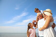 Cute little children with grandparents spending time together near sea