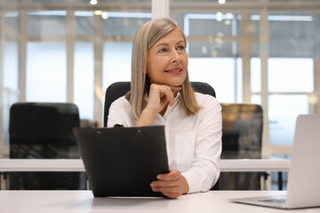 Poster - Smiling woman with clipboard working in office. Lawyer, businesswoman, accountant or manager