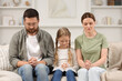 © New Africa - Girl and her godparents praying together on sofa at home