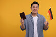 Immigration. Happy man with passport and flag of Germany on orange background, space for text