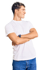 Wall Mural - Young handsome man wearing casual white tshirt looking to the side with arms crossed convinced and confident