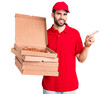 © Krakenimages.com - Young handsome man with beard wearing delivery uniform holding boxes with pizza smiling happy pointing with hand and finger to the side