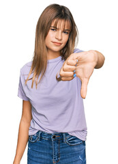 Wall Mural - Teenager caucasian girl wearing casual clothes looking unhappy and angry showing rejection and negative with thumbs down gesture. bad expression.