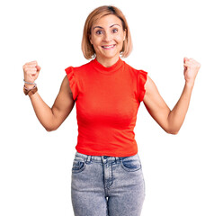 Wall Mural - Young blonde woman wearing casual clothes celebrating surprised and amazed for success with arms raised and open eyes. winner concept.