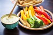 vegan queso dip with veggie sticks and gluten-free chips