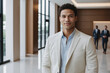 © EliteLensCraftImages - male young age multiracial hotel receptionist or manager standing in lobby with reception. welcoming guests, offering services or checkin. tourism and travel concept.