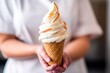 closeup shot of an unrecognizable woman holding a cone filled with soft serve ice cream