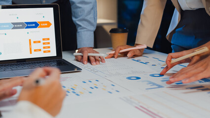 Wall Mural - Closeup asia businesspeople meeting plan analysis statistics brainstorm and header of team hold laptop point graph chart and employee take note at home office night. Finance strategy success concept.