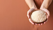 Hand holding organic rice grain isolated on pastel background
