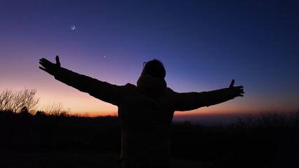 Wall Mural - man with arms wide open enjoying outdoors under stars, planets and moon..