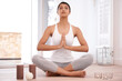© Miko/peopleimages.com - Woman, pray and meditation for yoga and mindfulness at home, fitness and health with healing and candles. Peace, calm and zen with young yogi in apartment, self care and wellness with aura balance
