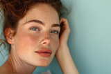 Fototapeta  - European woman with distinct freckles and melasma,woman's face showing, isolated a plain blue colored background.