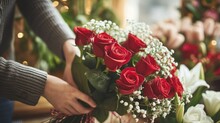 Florist's Hands Delicately Arranging A Vibrant Bouquet Of Red Roses