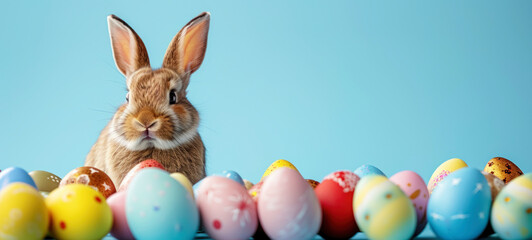 Wall Mural - Easter banner with colorful eggs and a little bunny rabbit on a blue background