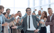 © ASDF - happy business man standing among his colleagues.