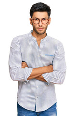 Wall Mural - Young handsome man wearing casual clothes and glasses skeptic and nervous, disapproving expression on face with crossed arms. negative person.