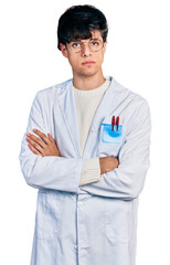 Poster - Handsome hipster young man with crossed arms wearing doctor uniform relaxed with serious expression on face. simple and natural looking at the camera.