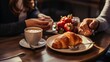 a close up of a plate of food on a table with a cup of coffee and a croissant.