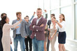 © ASDF - young businessman on the background of applauding business team.
