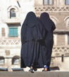 Two women in a black burka on a street in Yemen