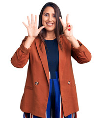 Sticker - Young beautiful brunette woman wearing elegant clothes showing and pointing up with fingers number seven while smiling confident and happy.