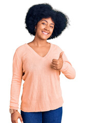 Poster - Young african american girl wearing casual clothes doing happy thumbs up gesture with hand. approving expression looking at the camera showing success.