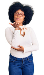 Canvas Print - Young african american girl wearing casual clothes and glasses looking at the camera blowing a kiss with hand on air being lovely and sexy. love expression.