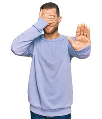 Poster - Young caucasian man wearing casual clothes covering eyes with hands and doing stop gesture with sad and fear expression. embarrassed and negative concept.