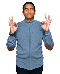 Wall Mural - Young handsome hispanic man wearing casual sweatshirt relaxed and smiling with eyes closed doing meditation gesture with fingers. yoga concept.