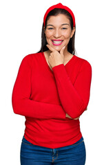 Wall Mural - Young hispanic woman wearing casual clothes looking confident at the camera smiling with crossed arms and hand raised on chin. thinking positive.