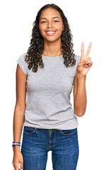 Sticker - Young african american girl wearing casual clothes showing and pointing up with fingers number two while smiling confident and happy.