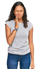 Wall Mural - Young african american girl wearing casual clothes touching mouth with hand with painful expression because of toothache or dental illness on teeth. dentist