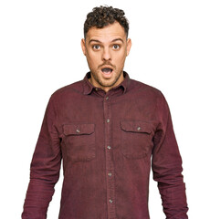 Wall Mural - Young hispanic man wearing casual clothes afraid and shocked with surprise and amazed expression, fear and excited face.