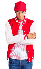 Wall Mural - Young african amercian man wearing baseball uniform skeptic and nervous, disapproving expression on face with crossed arms. negative person.