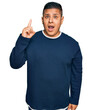 © Krakenimages.com - Young latin man wearing casual clothes pointing finger up with successful idea. exited and happy. number one.