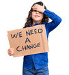 © Krakenimages.com - Cute hispanic child with long hair holding we need a change banner stressed and frustrated with hand on head, surprised and angry face