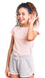 © Krakenimages.com - Beautiful kid girl with curly hair wearing casual clothes smiling with hand over ear listening an hearing to rumor or gossip. deafness concept.