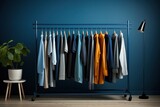 Fototapeta  - minimal rack with blue color palette male clothes on hangers. Open closet, dressing room for wardrobe at bachelor's apartment interior. Man outfits store.