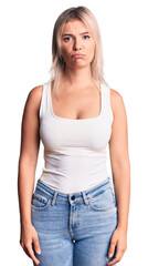 Wall Mural - Young beautiful blonde woman wearing casual sleeveless t-shirt depressed and worry for distress, crying angry and afraid. sad expression.