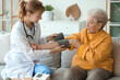 © Pixel-Shot - Doctor measuring blood pressure of senior woman at home